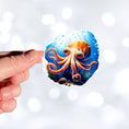 Load image into Gallery viewer, This image shows a hand holding the Big Eyed Octopus Die-Cut Sticker.
