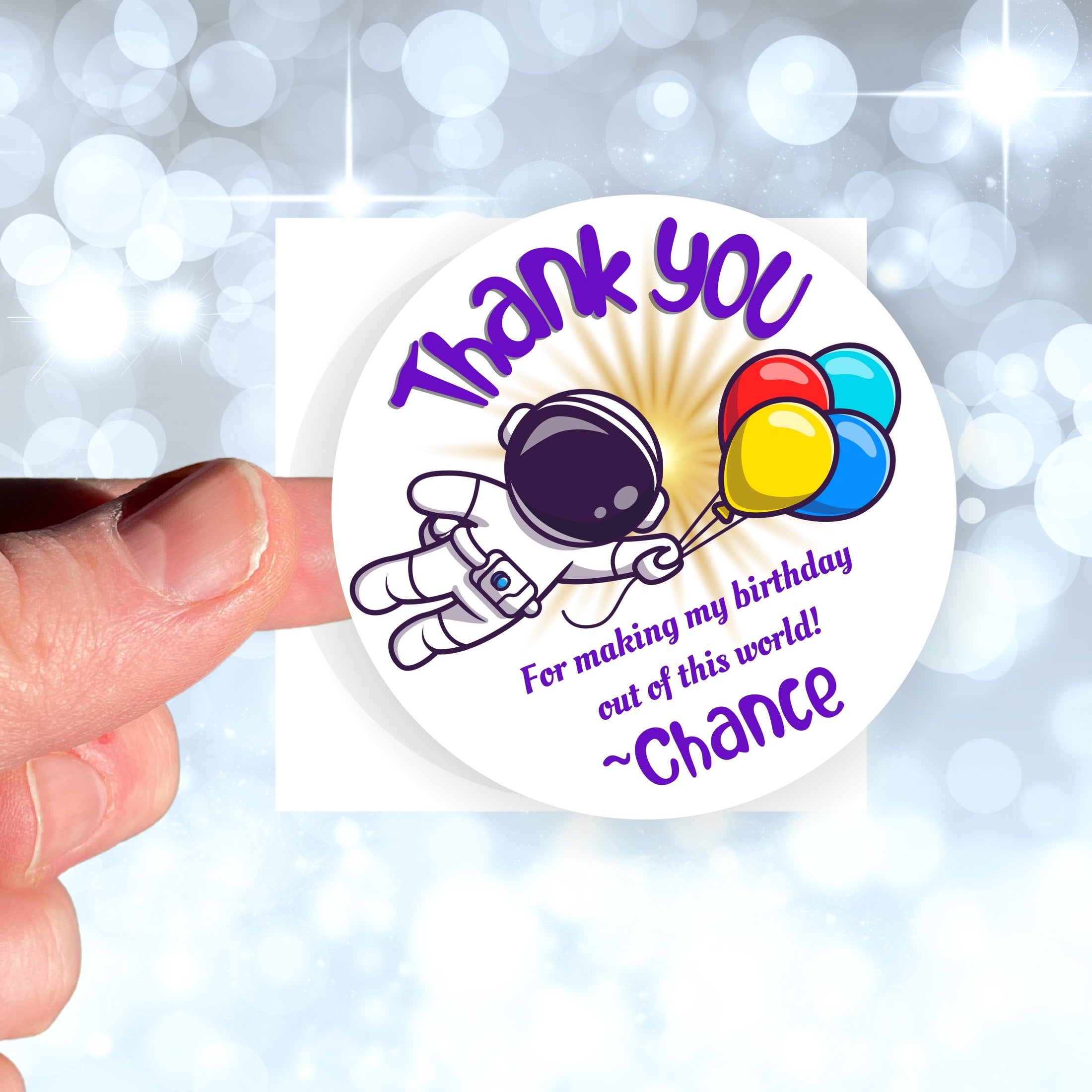 This image shows a hand holding the personalized astronaut themed thank you sticker.