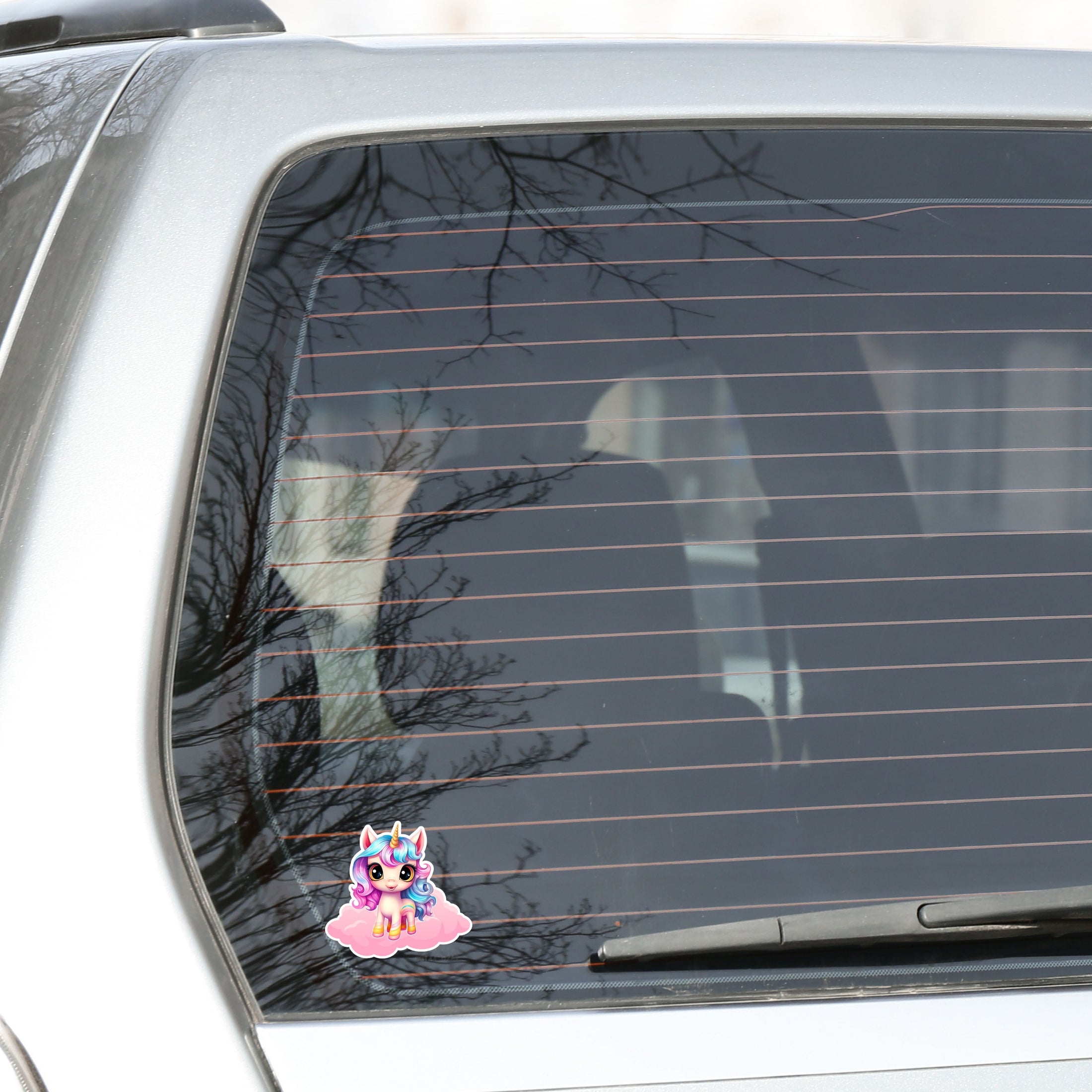 This image shows the pink chibi unicorn sticker on the back window of a car.
