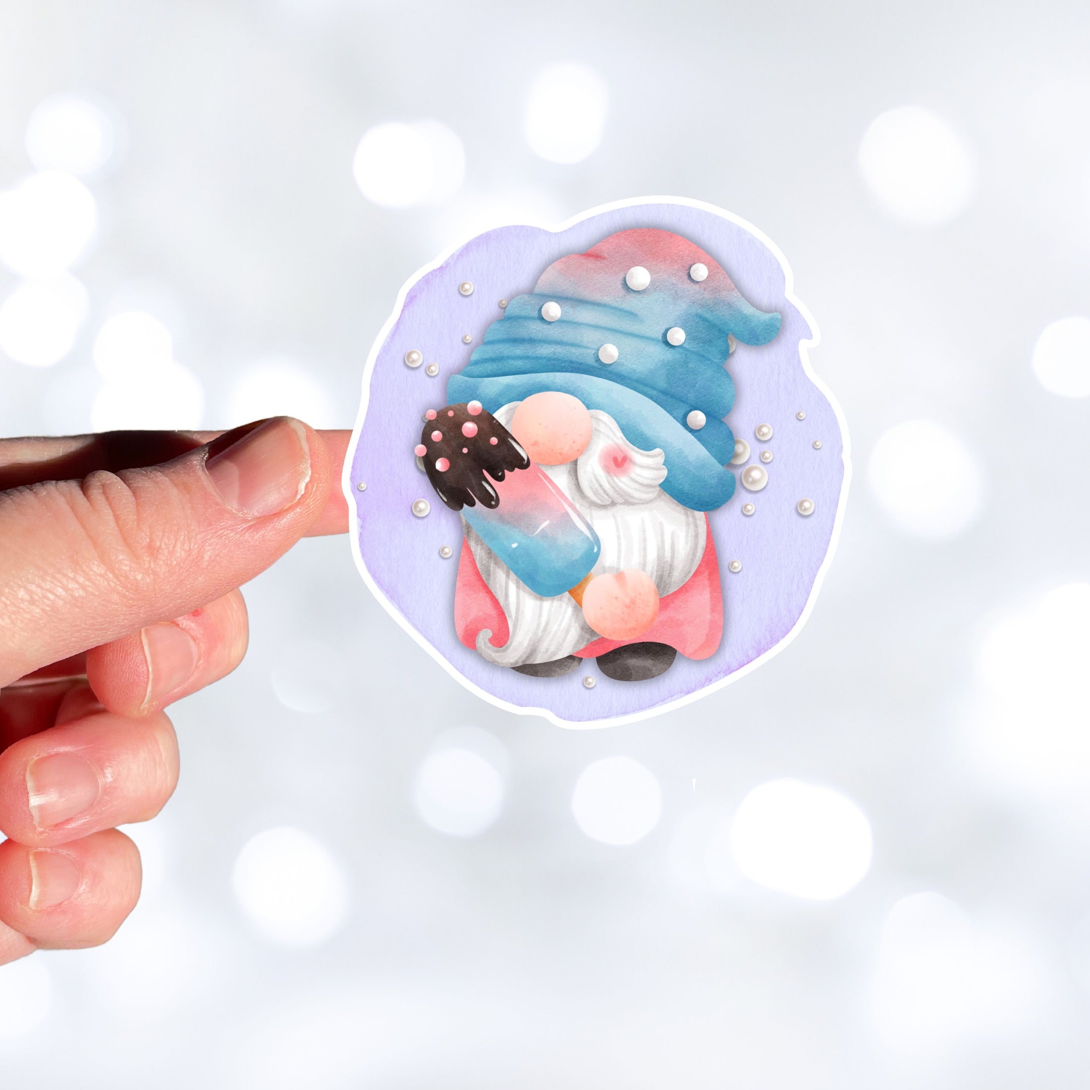 This image shows a hand holding the gnome with a popsicle sticker.