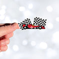 Load image into Gallery viewer, This image shows a hand holding the race car with flags sticker.
