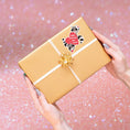 Load image into Gallery viewer, This image shows the valentine sticker on a package.
