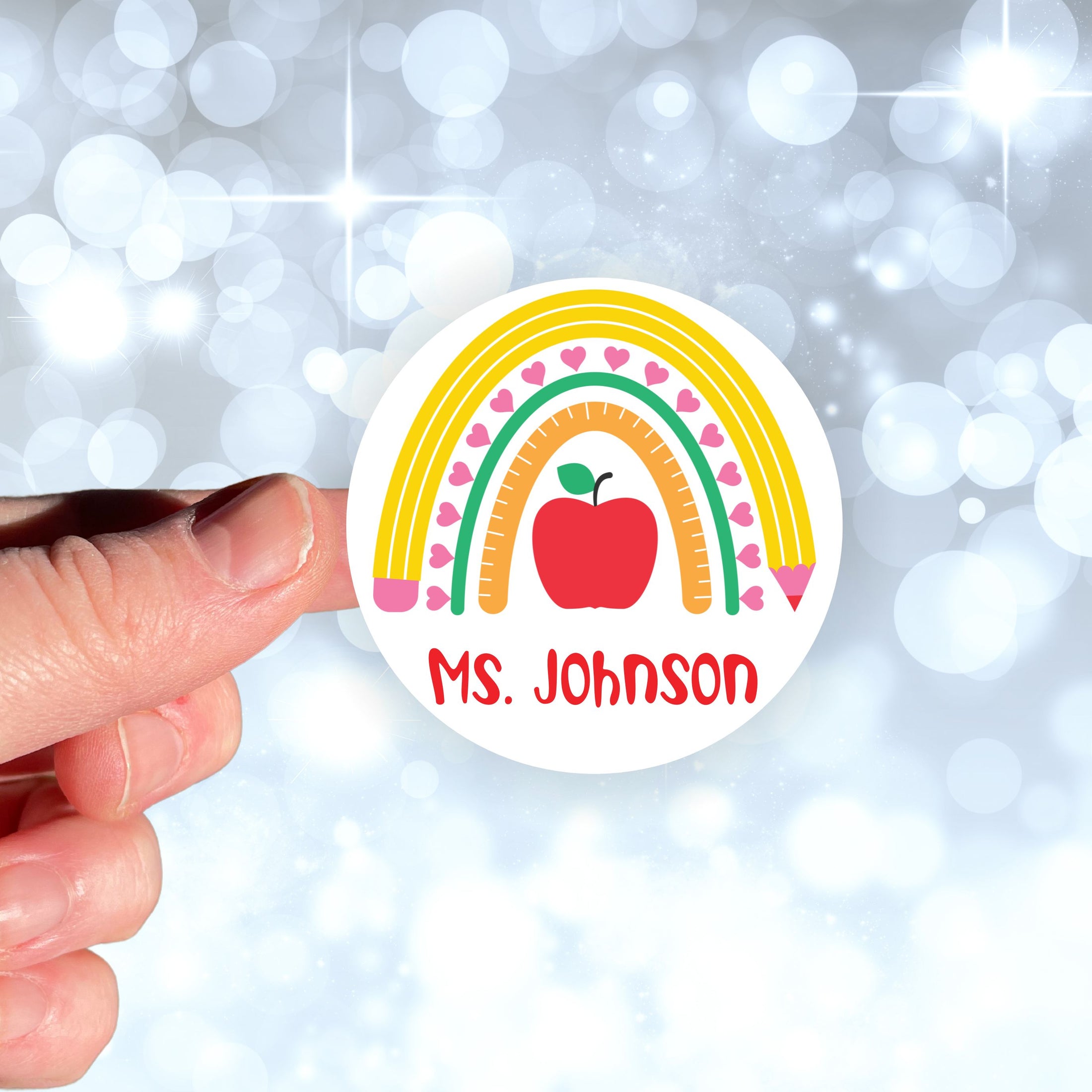 This image shows a hand holding the personalized school sticker.