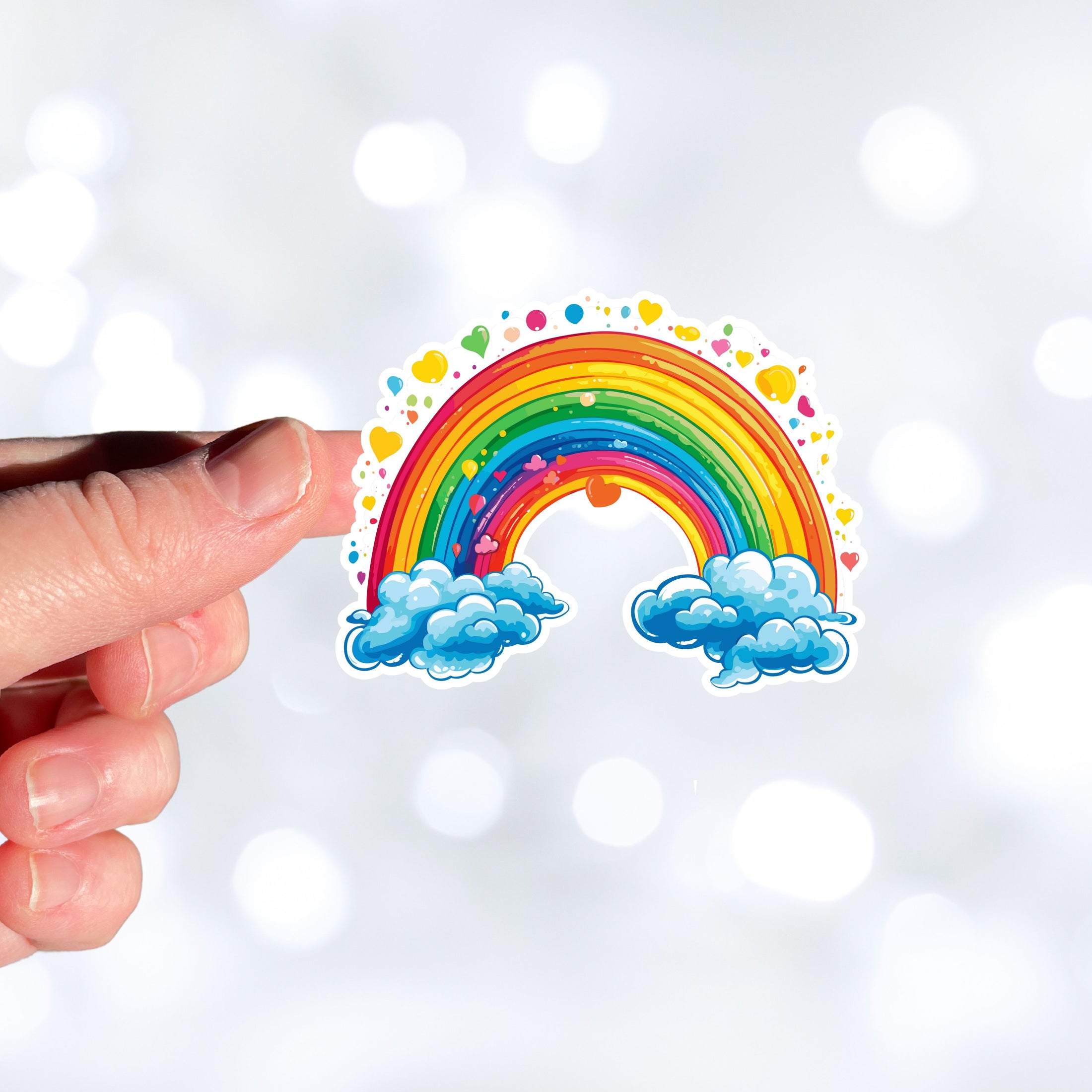 This image shows a hand holding the rainbow and hearts sticker.