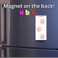 Load image into Gallery viewer, This image shows the To-Do List Notepad - Raspberry on the front of a refrigerator.
