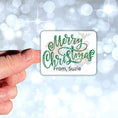 Load image into Gallery viewer, This image shows a hand holding the Personalized Holiday Stickers - Sloth Merry Christmas.
