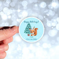 Load image into Gallery viewer, This image shows the personalized holiday sticker being held on one finger over a background of bubbles.
