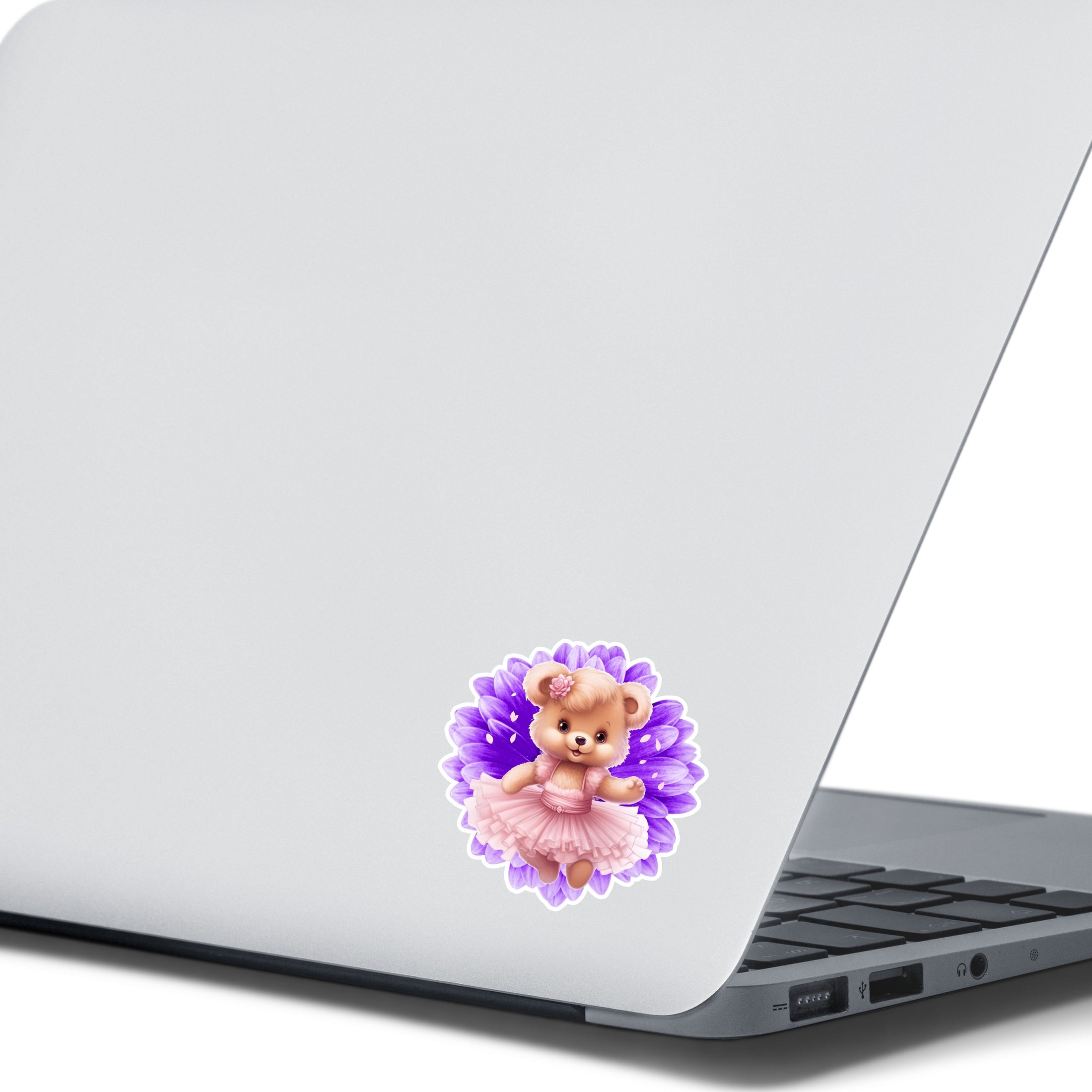 This image shows the teddy bear on purple sticker on the back of an open laptop.