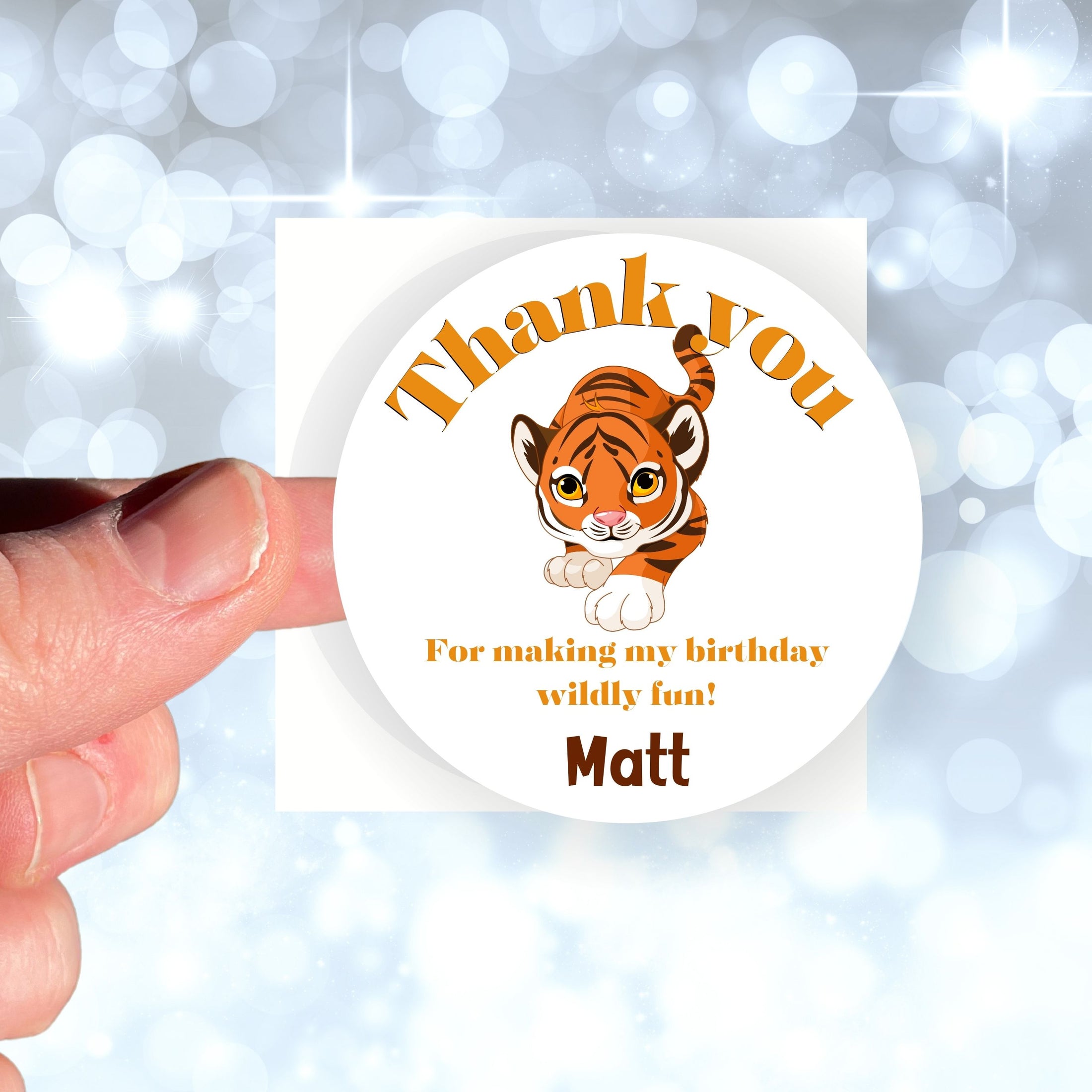 This image shows a hand holding the personalized wild animal themed thank you sticker.