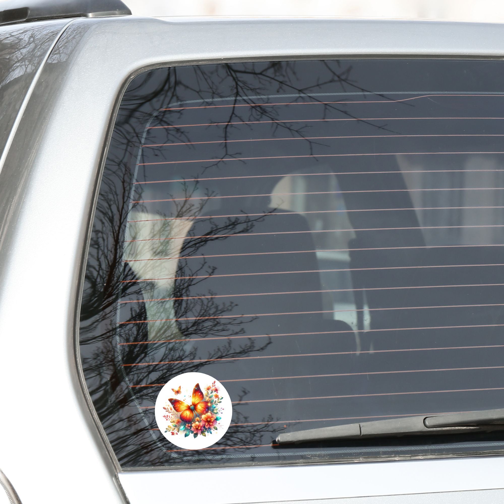 This image shows the Orange Butterfly with Stars Die-Cut Sticker on the back window of a car.