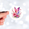 Load image into Gallery viewer, This image features a hand holding the Pink Butterfly with Stars Die-Cut Sticker.
