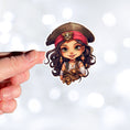 Load image into Gallery viewer, This image shows a hand holding the Pirate Girl Die-Cut Sticker.
