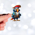 Load image into Gallery viewer, This image shows a hand holding the Pirate Parrot Die-Cut Sticker.
