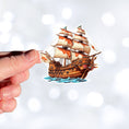 Load image into Gallery viewer, This image shows a hand holding the Pirate Ship Die-Cut Sticker.
