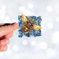 Load image into Gallery viewer, This image shows a hand holding the steampunk bee die-cut sticker.
