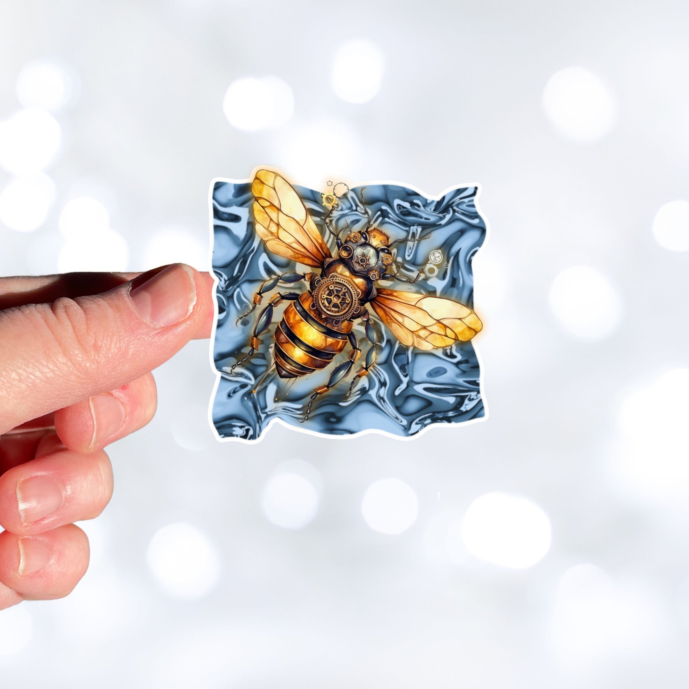 This image shows a hand holding the steampunk bee die-cut sticker.