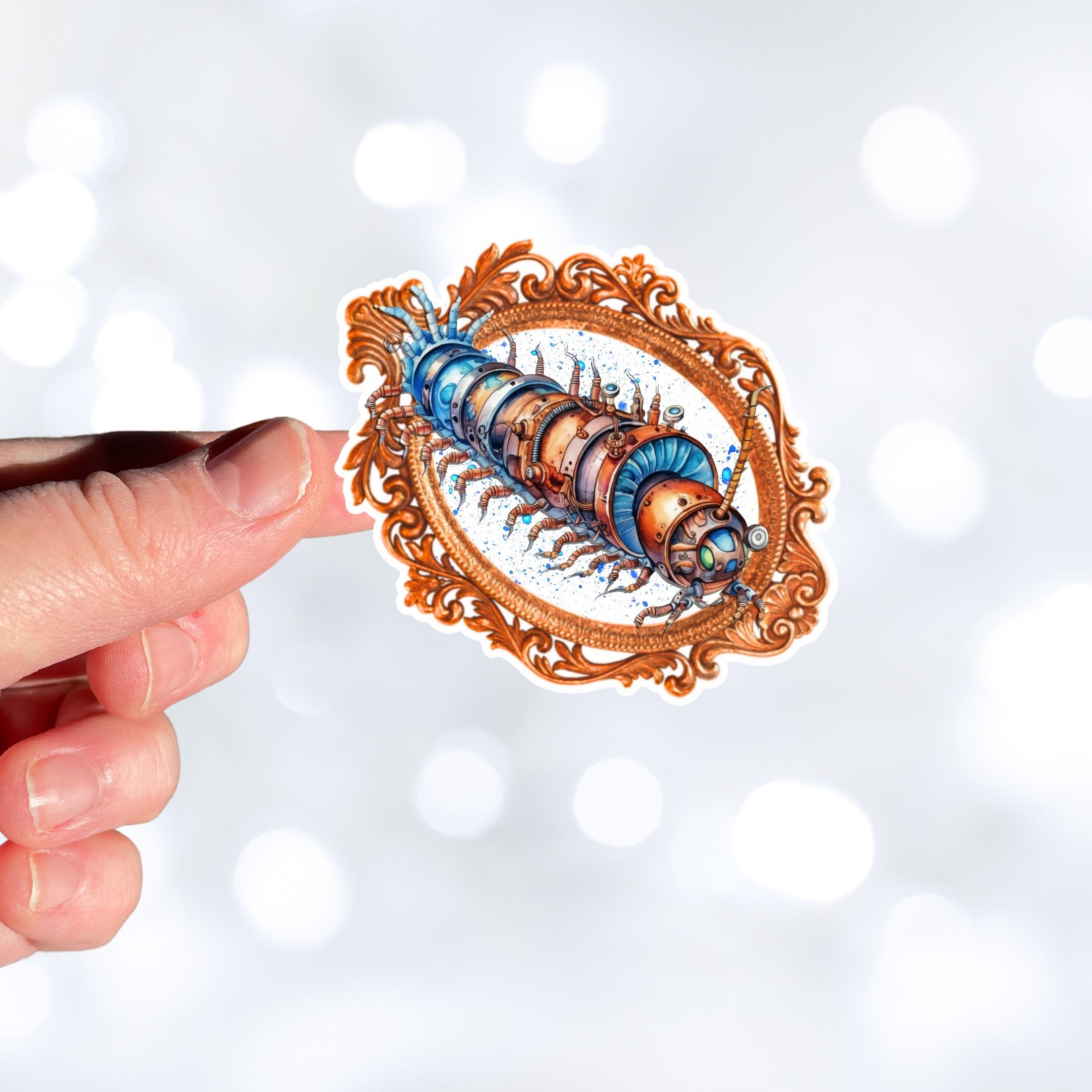 This image shows a hand holding the steampunk centipede sticker.