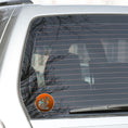 Load image into Gallery viewer, This image shows the steampunk dragon with copper background on the back window of a car.
