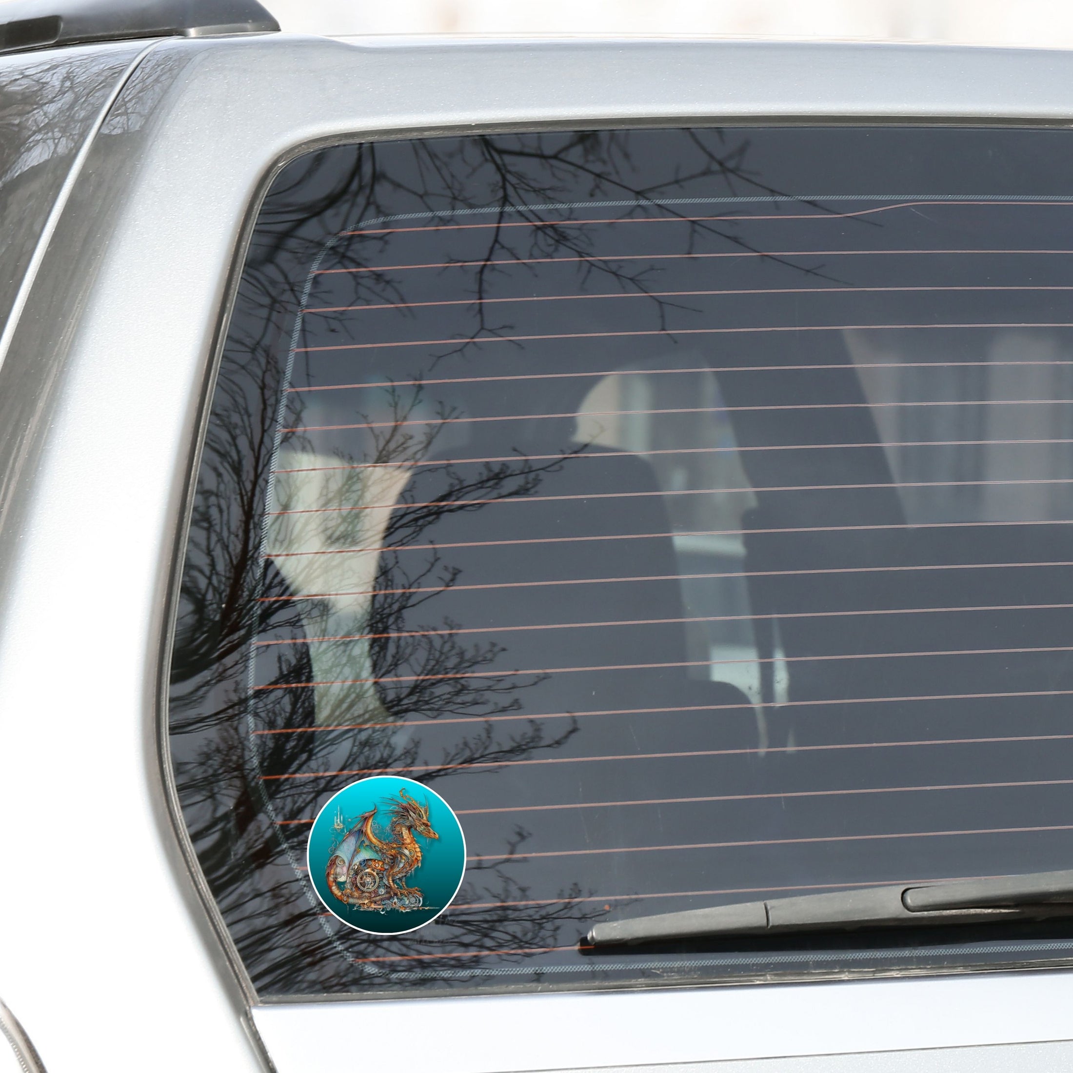 This image shows the steampunk dragon on a blue background sticker on the back window of a car.
