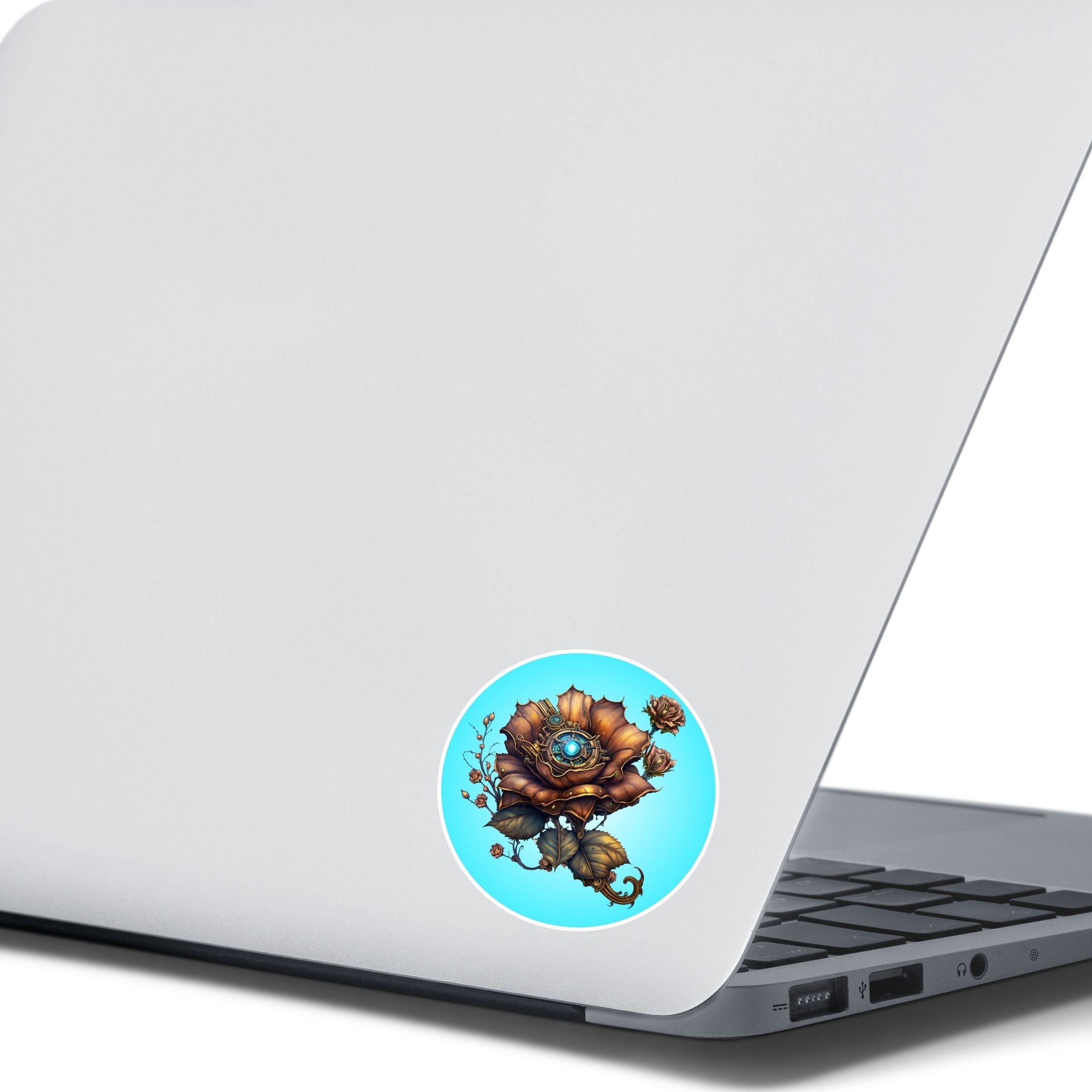 This image shows a steampunk bronzed flower sticker on the back of an open laptop.
