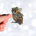 Load image into Gallery viewer, This image shows the steampunk owl sticker on a finger.
