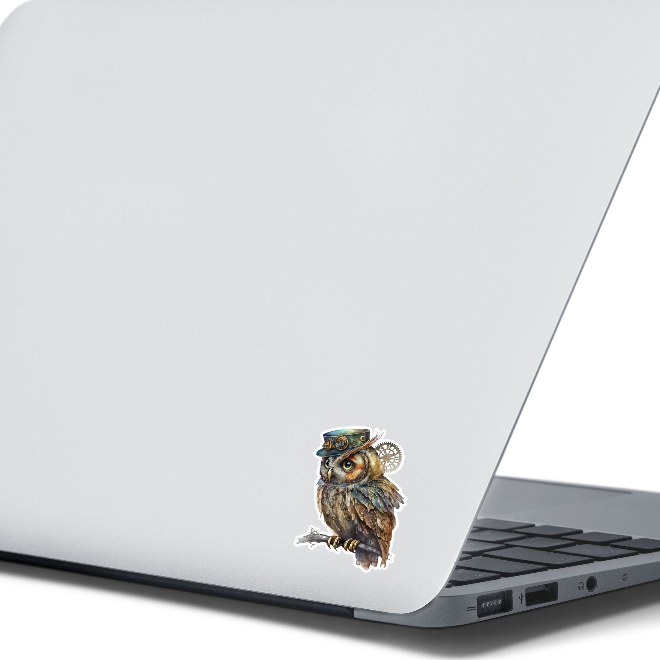 This image shows the steampunk owl sticker on the back of an open laptop.