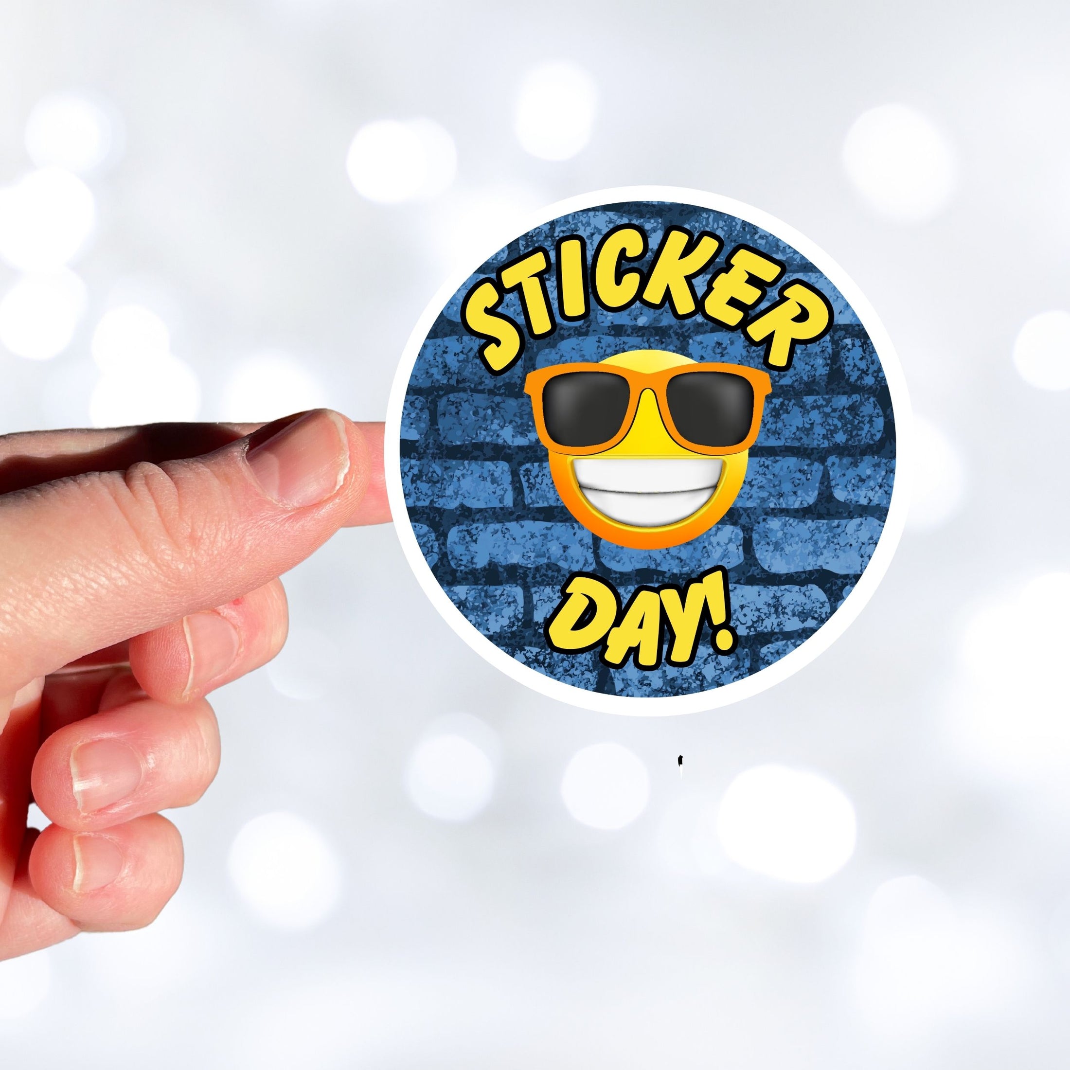 This image shows a hand holding the sticker day sticker.