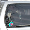 Load image into Gallery viewer, This individual die-cut sticker is one you either like or don't like; it's very unique! Featuring a 3D paint drip in pinks and purples over a green and blue paint swath, this sticker is hard to explain but pretty interesting to see. This image shows the 3D Drip sticker on the back window of a car.
