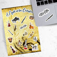 Load image into Gallery viewer, This sticker sheet celebrates all things music! Strings, brass, woodwinds, and percussion stickers that are perfect for any music lover. This image shows the sticker sheet next to an open laptop with a sticker of a music notes surrounded by leaves and vines and a sticker of a flute applied below the keyboard.
