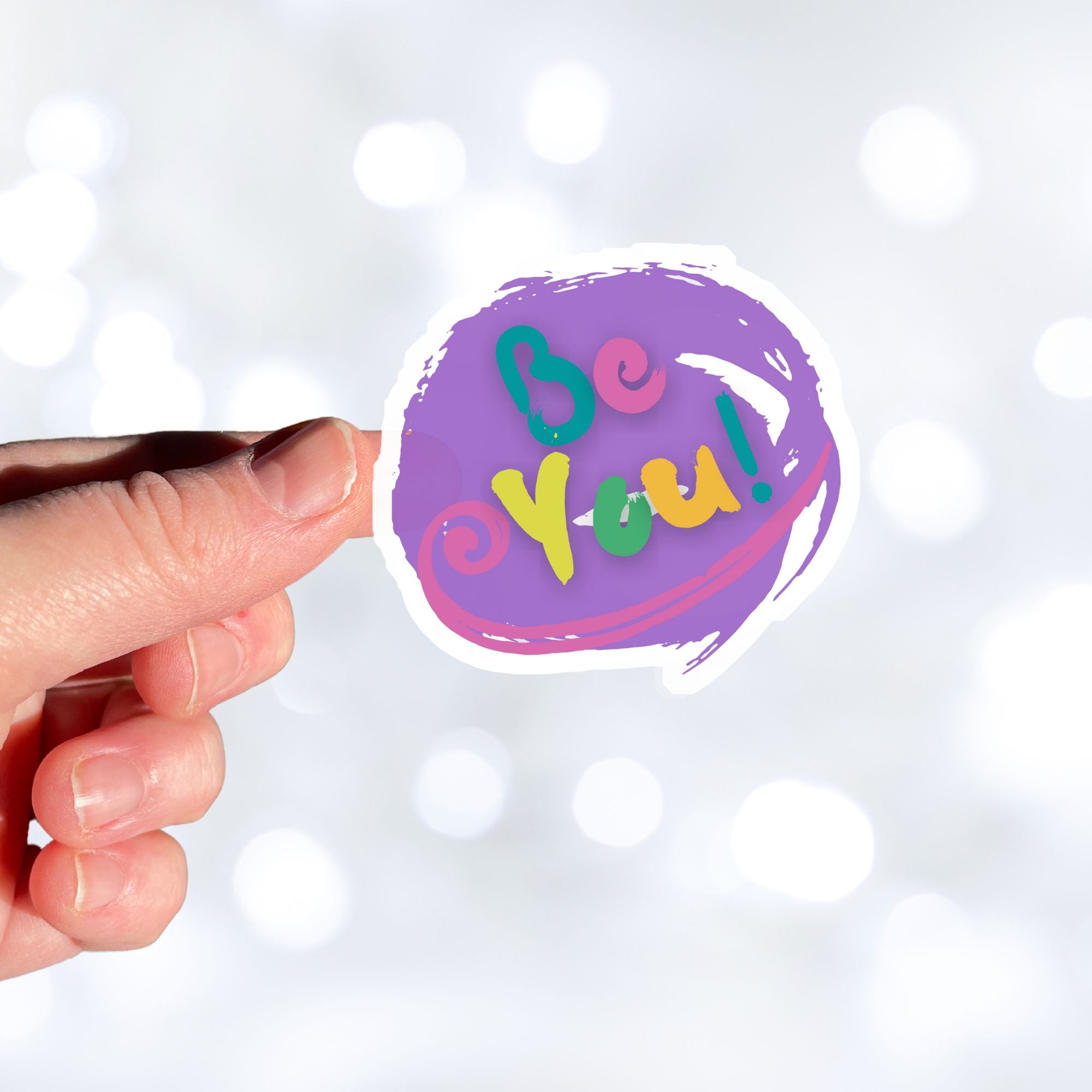 Be You - words to live by! This individual die-cut sticker features "Be You" in multiple pastel colors on a lavender background. This image shows a hand holding the Be You! sticker.