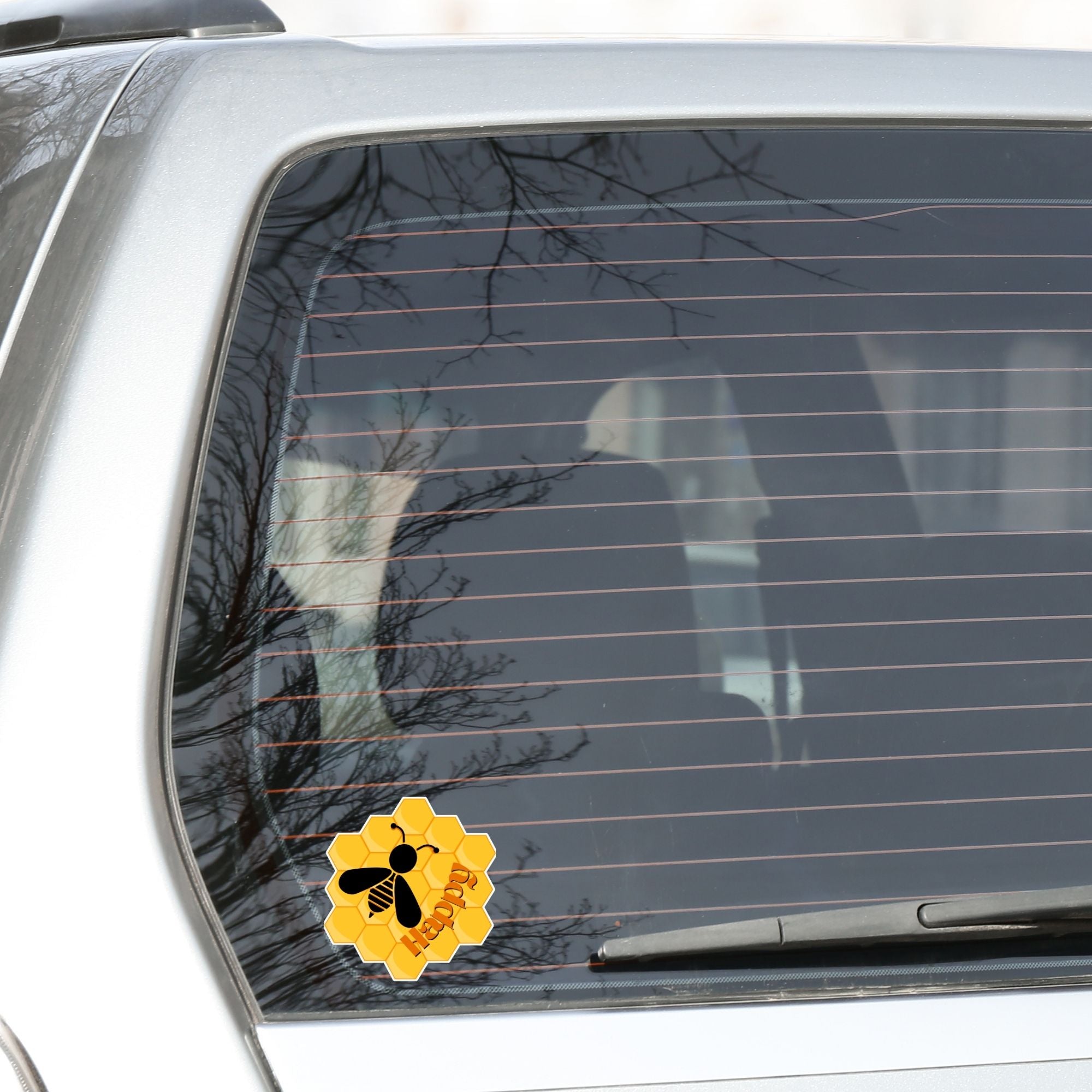 Bee Happy! This individual die-cut sticker is a great motivator. It features a honeycomb background with the silhouette of a bee and the word happy - enough said! This image shows the Bee Happy die-cut sticker on the back window of a car.