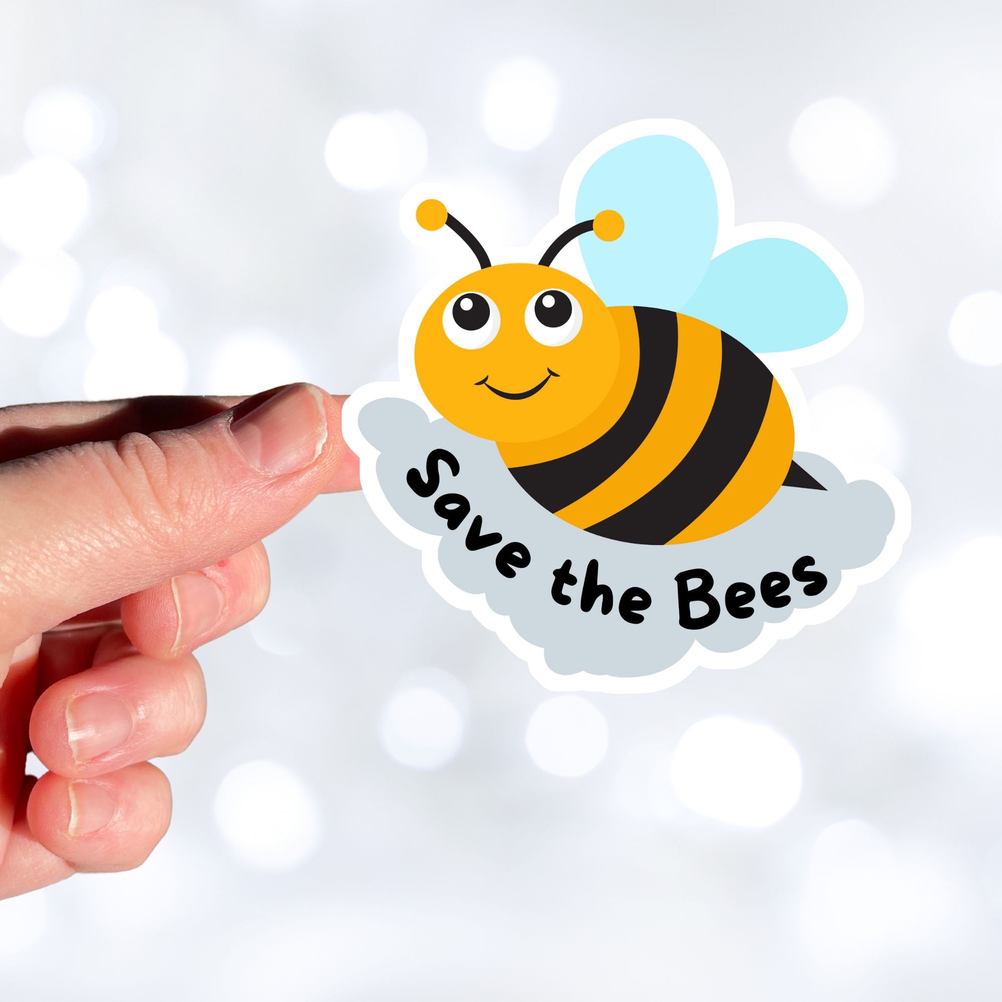 This cute individual die-cut sticker is great for anyone who appreciates our environment or just wants to smell the flowers. The Save the Bees sticker has a happy bumblebee with the saying Save the Bees below. Pair it with our Flowers, Ladybugs and Bees, or Buggin Around sticker sheets for a great gift. This image shows a hand holding the Save the Bees sticker.