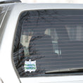 Load image into Gallery viewer, For those who like it, caffeine can be the magic elixir! This individual die-cut sticker has the words Powered by CAFFEINE in green over a background of blue electric/lightning bolts. This image shows the Powered by Caffeine sticker on the back window of a car. 
