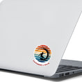 Load image into Gallery viewer, Hang 10 Bro! Catch a wave with this individual die-cut sticker featuring the silhouette of a male surfer inside the tube, all on a colored gradient background. Cowabunga!  This image shows the Catching a Wave sticker on the back of an open laptop.
