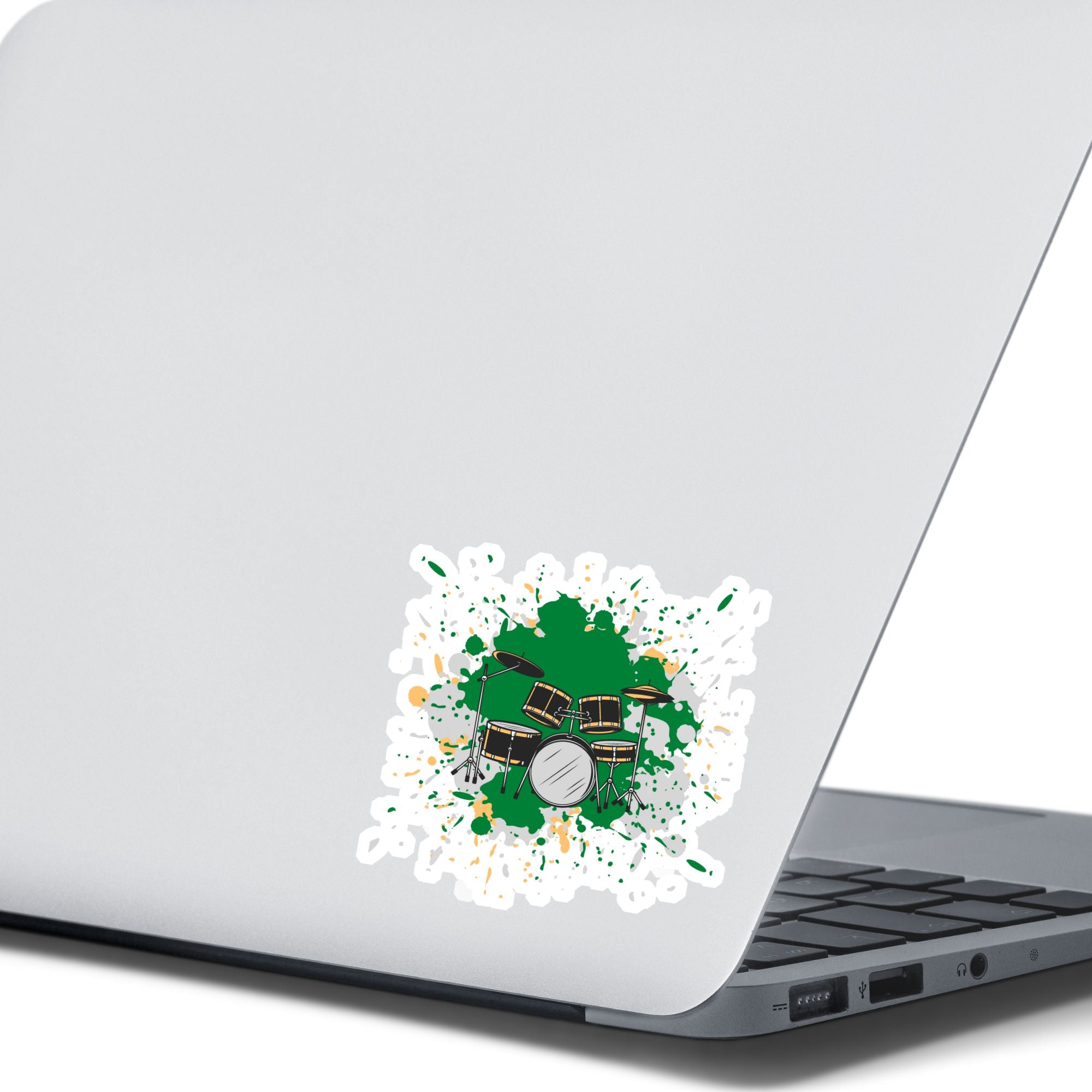 Drummer's, this individual die-cut sticker is for you! It features a drum kit on a green and gray paint splashed background. This drum sticker makes a great gift for anyone who loves to hit the skins. This image shows the drums die-cut sticker on the back of an open laptop.