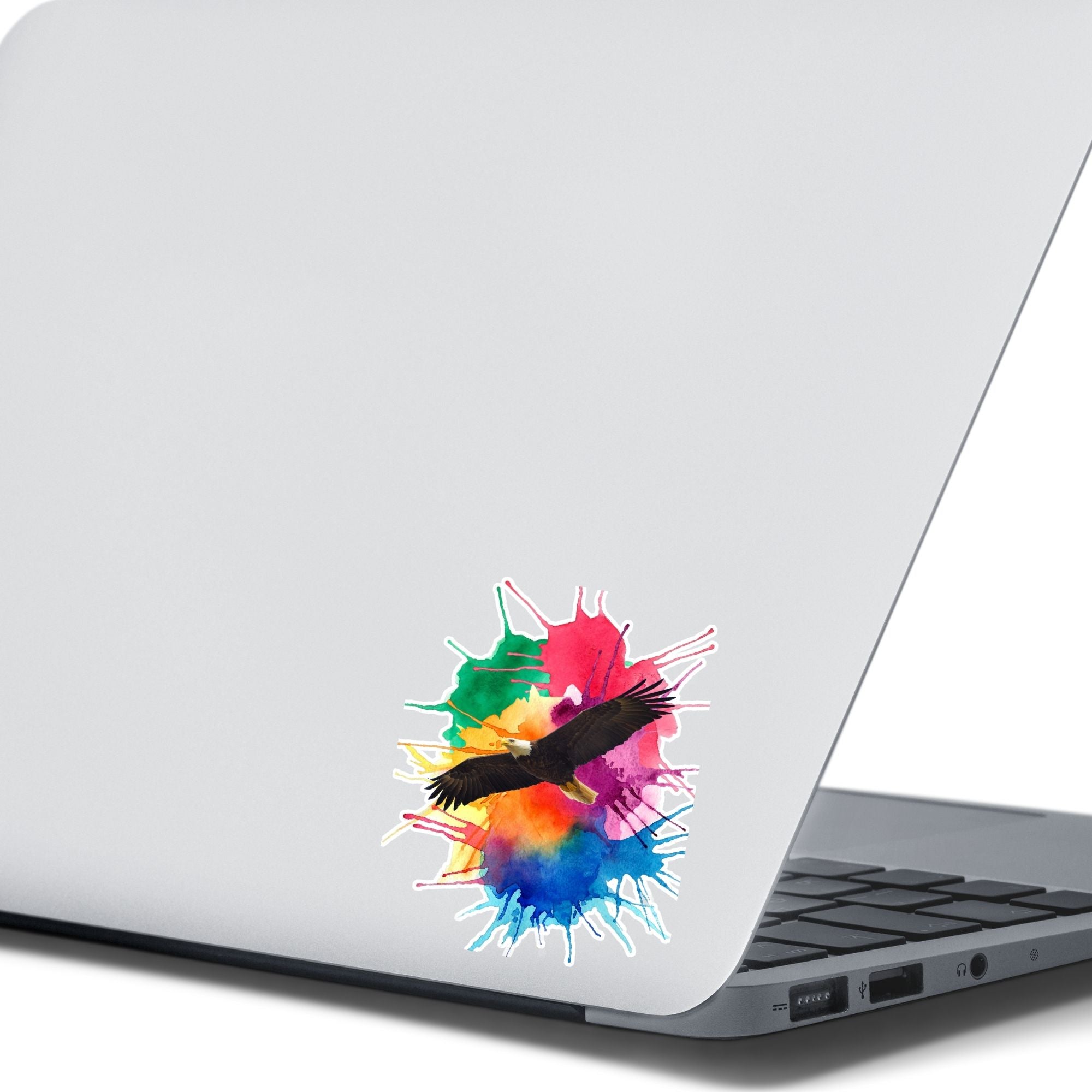 Soar with Eagles! This individual die-cut sticker features a majestic eagle soaring over a paint splash background. This image shows the Soaring Eagle sticker on the back of an open laptop.