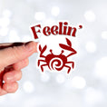 Load image into Gallery viewer, Feelin Crabby? Naw, but sometimes this die cut sticker of a crab is just right for nearly everyone! This image shows a hand holding the Feelin Crabby sticker.
