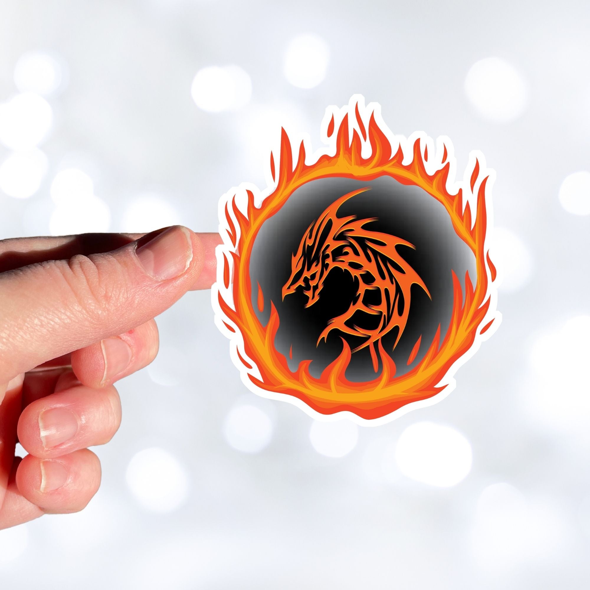 Who dares to disturb the Fire Dragon? This individual die-cut sticker features a fiery orange dragon surrounded by a ring of fire.  This image shows a hand holding the Fire Dragon sticker.