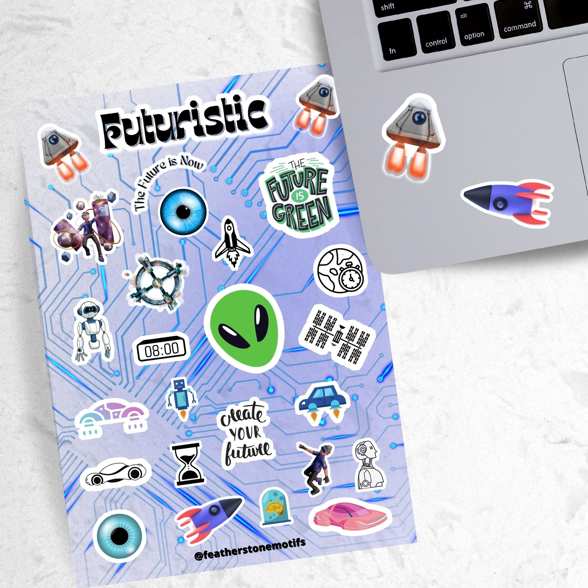 Set on a background of a circuit board, this sticker sheet is filled with futuristic sticker images like rocket ships, flying cars, aliens, and robots, and it has a holographic star overlay! This image shows the sticker sheet next to an open laptop with two different rocket stickers applied below the keyboard.