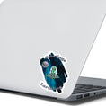 Load image into Gallery viewer, Welcome space aliens! This individual die-cut sticker features a friendly green space alien in a flying saucer, on a background of stars with the moon behind, and the words "Greetings Earthling". This image shows the flying saucer sticker on the back of an open laptop.

