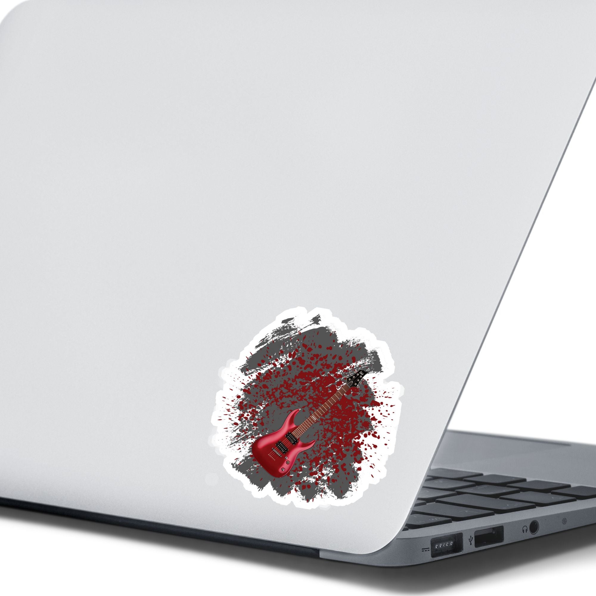 This guitar sticker is great for any guitarist, whether a beginner or a seasoned shredder! This individual die-cut sticker features a burgundy electric guitar on a gray and burgundy paint splattered background. Turn it up!  This image shows the guitar sticker on the back of an open laptop.