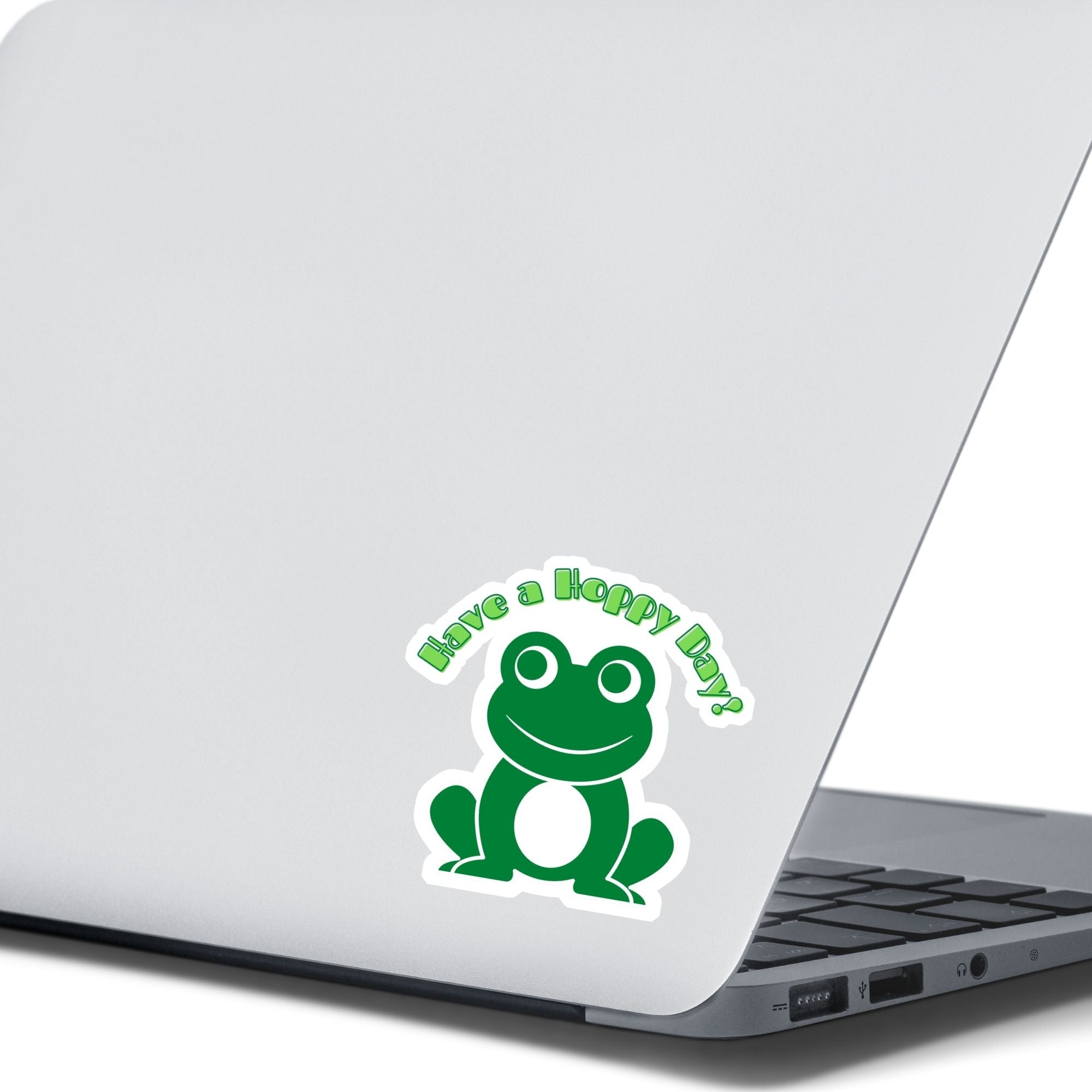 This inspirational sticker features a smiling frog with "Have a Hoppy Day!" written above. This image shows the Have a Hoppy Day sticker on the back of an open laptop.