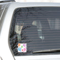 Load image into Gallery viewer, Float away on a colorful hot air balloon! This individual die-cut hot air balloon sticker has six, yes six, different hot air balloons on a background of clouds. This image shows the hot air balloon die-cut sticker on the back window of a car.
