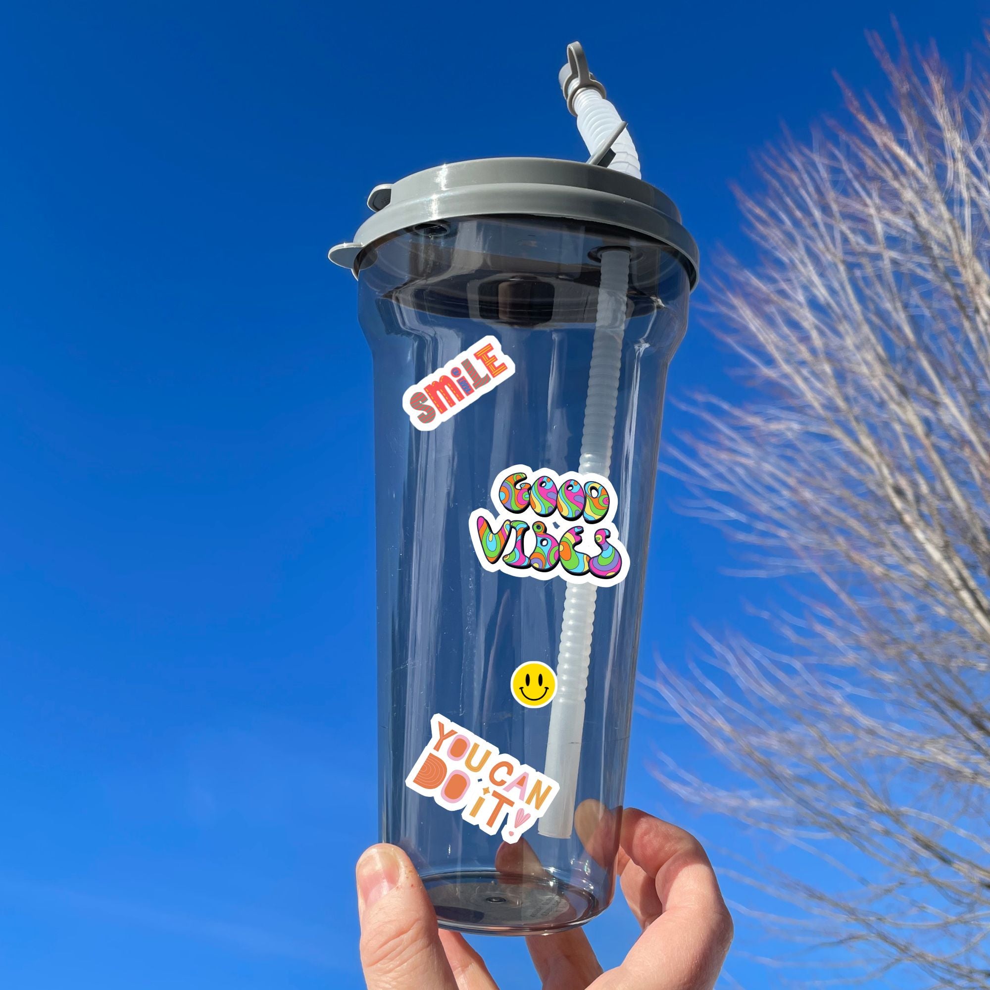 Feel good with these inspirational thoughts as stickers! This sheet has a dozen stickers with inspirational sayings, plus some smaller stickers to help brighten anyone's day. This image shows a water bottle with "Smile", "Good Vibes", and "You can do it!" stickers along with a small happy face applied to the bottle.