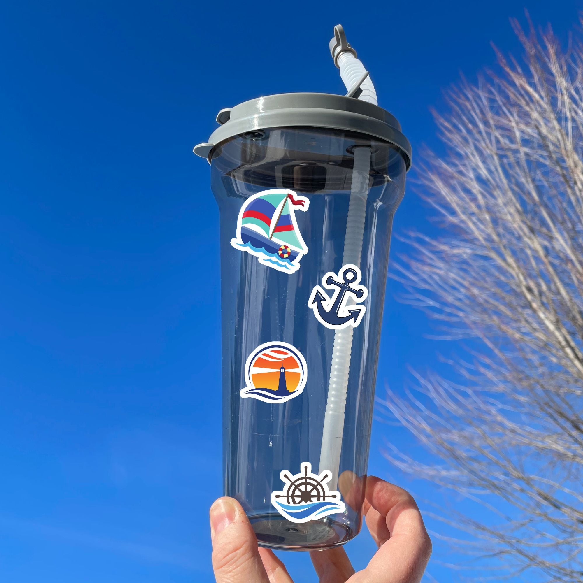 Permission to come aboard and sail away? This sticker sheet has twelve different sailing designs perfect for any captain or first mate! This image shows a water bottle with 4 stickers applied: Sailboat sticker, anchor sticker, lighthouse with a sunrise or sunset, and ships wheel and waves.