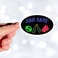 Load image into Gallery viewer, Guys, want to celebrate your man cave? Then this individual die-cut sticker is just what you need! It features a black background with neon images of "Man Cave" written above a football, clinking bottles, and slice of pizza. What more could you want? This image shows a hand holding the Man Cave sticker.
