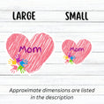 Load image into Gallery viewer, Show how much you love your mom with this individual die-cut sticker. This makes a great gift for mom, or for all mom's to proudly show they are a mother! This sticker features a pink scribbled heart with Mom written across the middle and 5 small paint hands on the lower left side. This image shows large and small Mom stickers next to each other.
