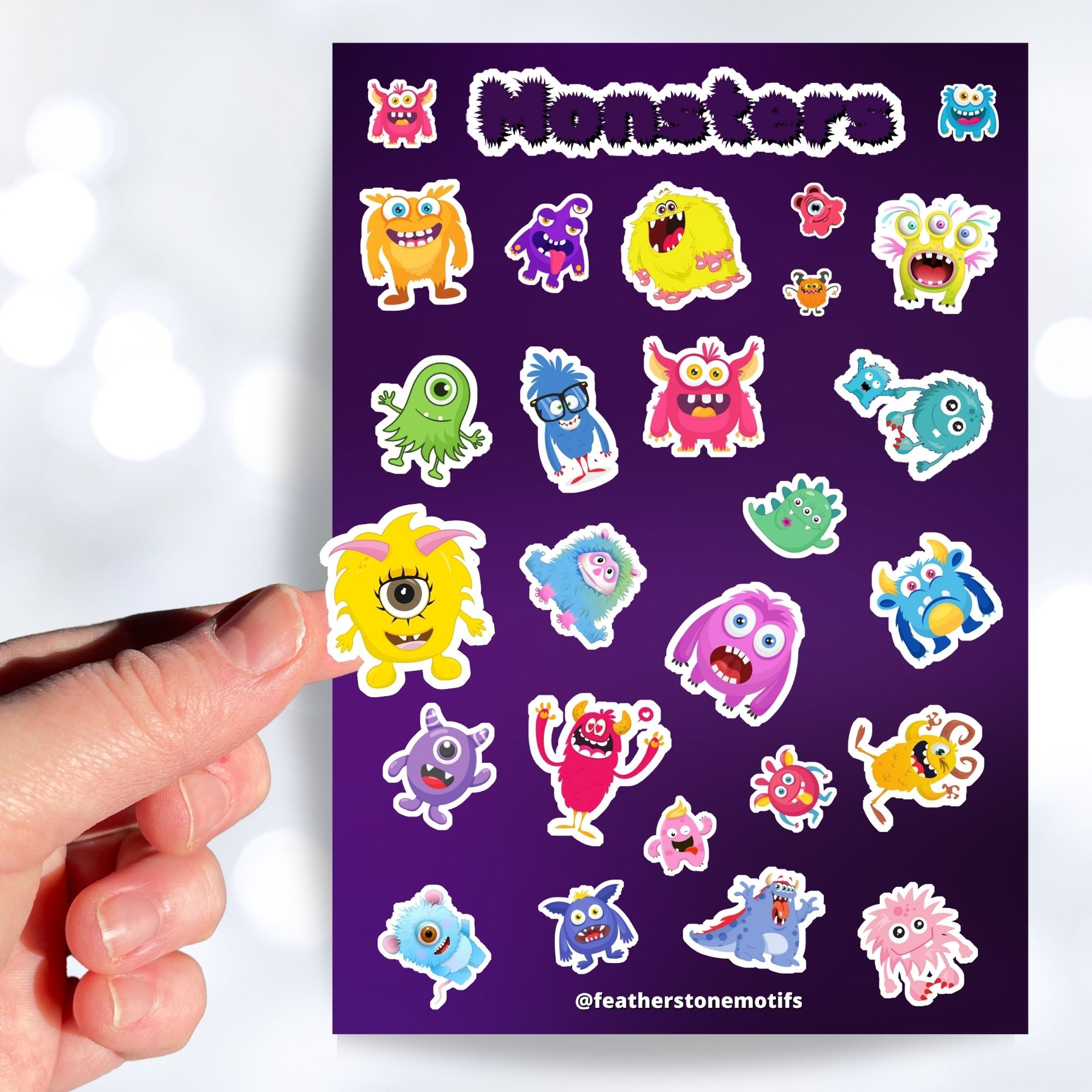Don't look under the bed! No - these monster's aren't scary! This sticker sheet is filled with sticker images of cute and fun monsters that kids aged 1 to 100 will enjoy. This image shows a hand holding a yellow one eyed monster sticker above the sticker sheet.