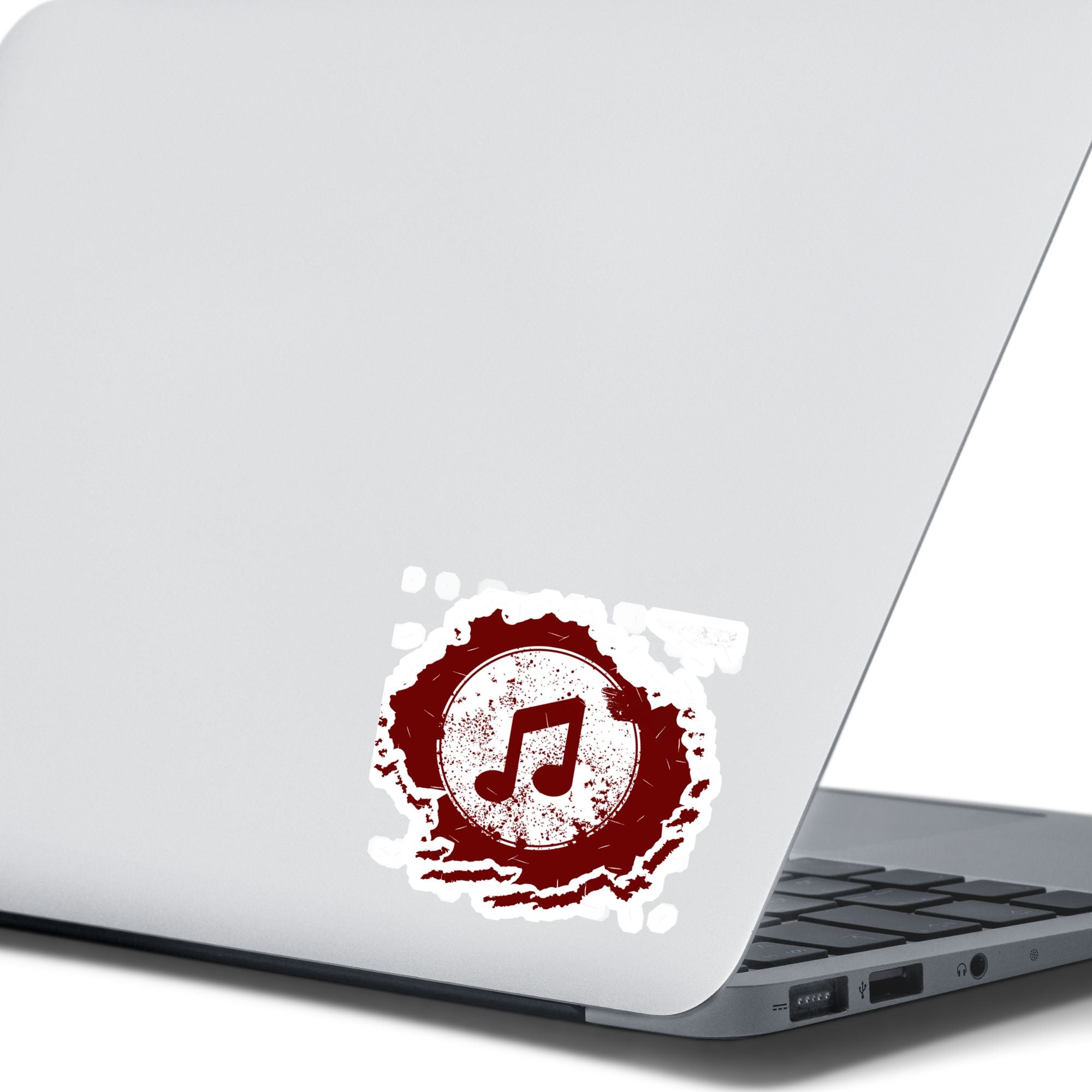 This individual die-cut sticker features a double music note in brown with a paint splattered background. Perfect for performers and music lovers alike!  This image shows the music note sticker on the back of an open laptop.
