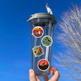 Load image into Gallery viewer, Tie up your boots and enter the wild with this sticker sheet! This sticker sheet has twelve different stickers showing different outdoor activities. From the mountains to camping to climbing this set is perfect for any outdoors person. This image is of a water bottle with four different outdoor stickers applied to it.
